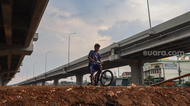 Seorang anak menjajal area lintasan Pump Track di Bike Park Pilar Jati, Kolong Tol Becakayu, Jakarta Timur, Minggu (25/10). [Suara.com/Alfian Winanto]