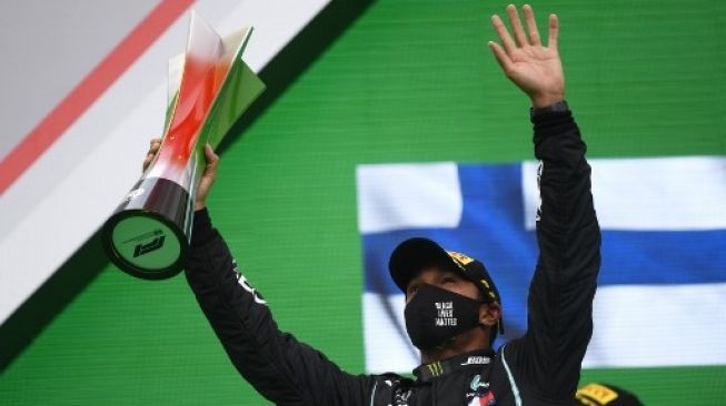 Pembalap Mercedes Lewis Hamilton merayakan kemenangannya di podium setelah menjuarai F1 GP Portugal di Autodromo Internacional do Algarve. RUDY CAREZZEVOLI / POOL / AFP