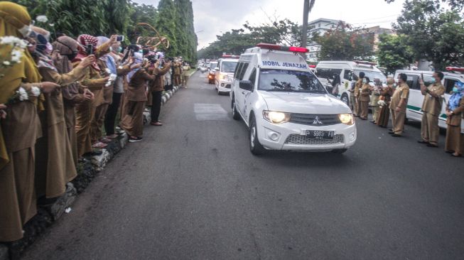 Sejumlah tenaga medis Dinas Kesehatan Kabupaten Bogor memberikan penghormatan terakhir kepada jenazah Kepala Puskesmas Banjarsari Dokter Usman, yang meninggal akibat COVID-19 di Jalan Raya Tegar Beriman, Kabupaten Bogor, Jawa Barat, Senin (26/10/2020). [ ANTARA FOTO/Yulius Satria Wijaya]