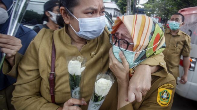 Sejumlah tenaga medis Dinas Kesehatan Kabupaten Bogor terisak tangis saat memberikan penghormatan terakhir kepada jenazah Kepala Puskesmas Banjarsari Dokter Usman, yang meninggal akibat COVID-19 di Jalan Raya Tegar Beriman, Kabupaten Bogor, Jawa Barat, Senin (26/10/2020).  [ ANTARA FOTO/Yulius Satria Wijaya]