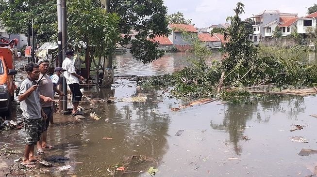 Sejumlah warga manfaatkan memancing di tengah banjir di Perumahan Griya Cimanggu Indah Bogor, Senin (26/10/2020). [Suara.com/Andi Ahmad Sulaendi]