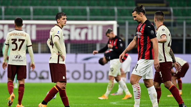 Penyerang AC Milan Zlatan Ibrahimovic (kanan) meninggalkan lapangan pada akhir pertandingan sepak bola Serie A Italia antara AC Milan melawan AS Roma di Stadion Meazza, Milan, Selasa (27/10) dini hari WIB. [MIGUEL MEDINA / AFP]