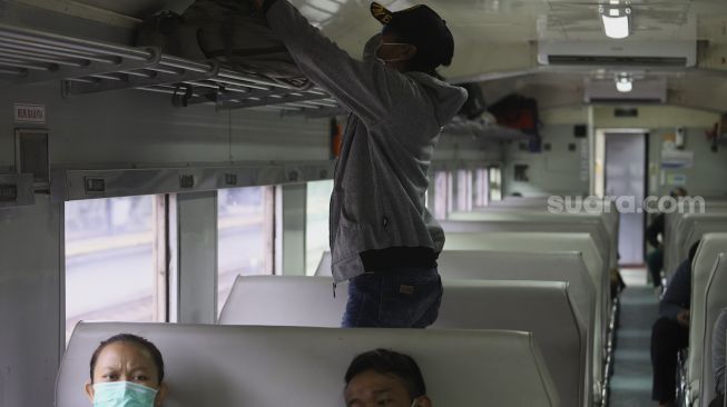 Sejumlah penumpang berada di dalam rangkaian Kereta Api Matarmaja yang berhenti di Stasiun Pasar Senen, Jakarta, Selasa (27/10/2020). [Suara.com/Angga Budhiyanto]