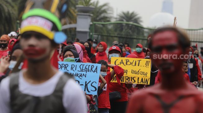 Massa dari Serikat Rakyat Miskin Indonesia (SRMI) membawa poster saat melakukan aksi unjuk rasa di kawasan Patung Kuda Arjuna Wiwaha, Jakarta, Selasa (27/10/2020). [Suara.com/Angga Budhiyanto]