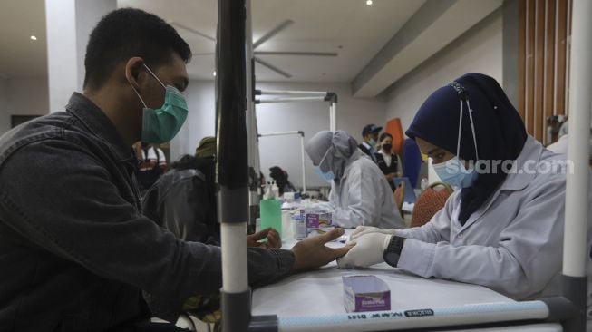 Calon penumpang melakukan tes diagnostik cepat atau rapid test di Stasiun Pasar Senen, Jakarta, Selasa (27/10/2020). [Suara.com/Angga Budhiyanto]