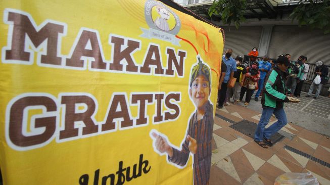 Warga mengantre untuk mendapatkan makanan secara gratis di gerobak makanan milik Setiyono di jalan Kedungsari, Surabaya, Jawa Timur, Selasa (27/10/2020).  [ANTARA FOTO/Moch Asim]