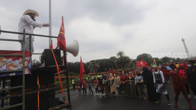 Massa dari Serikat Rakyat Miskin Indonesia (SRMI) berorasi dari atas mobil komando saat melakukan aksi unjuk rasa di kawasan Patung Kuda Arjuna Wiwaha, Jakarta, Selasa (27/10/2020). [Suara.com/Angga Budhiyanto]