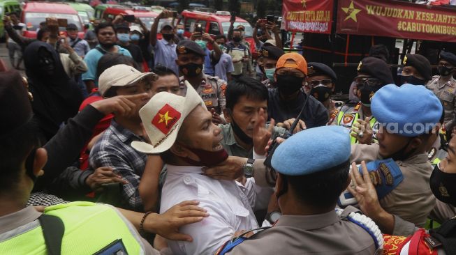 Massa dari Serikat Rakyat Miskin Indonesia (SRMI) bersitegang dengan aparat kepolisian saat melakukan aksi unjuk rasa di kawasan Patung Kuda Arjuna Wiwaha, Jakarta, Selasa (27/10/2020). [Suara.com/Angga Budhiyanto]