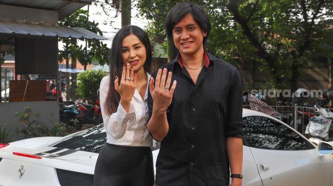 Musisi Kevin Aprilio bersama dengan istrinya, Vicy Melanie berpose sambil menunjukan cincin di jari manis mereka saat ditemui di Lebak Bulus, Jakarta Selatan, Rabu (28/10). [Suara.com/Alfian Winanto]