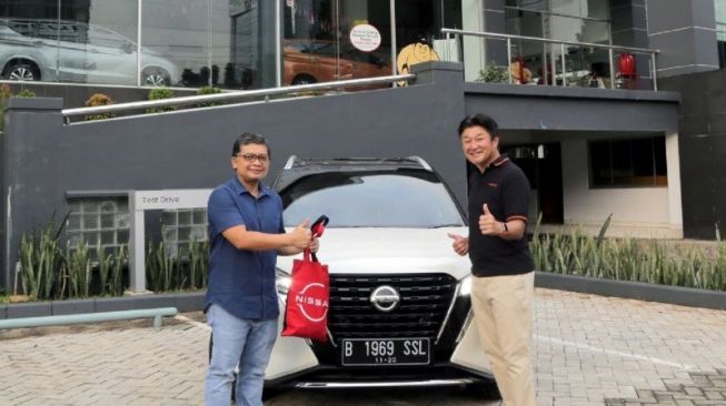 Isao Sekiguchi, presiden direktur Nissan di Indonesia bersama pembeli pertama All-New Nissan Kicks e-POWER, Yuriadi Sulastomo [Nissan Indonesia via ANTARA/HO].