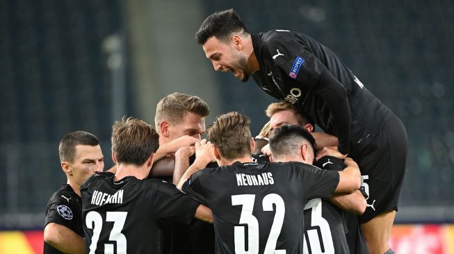 Penyerang Moenchengladbach Marcus Thuram merayakan golnya usai mencetak gol pembuka bersama rekan satu timnya selama pertandingan sepak bola grup B Liga Champions antara Borussia Moenchengladbach melawan Real Madrid di Borussia Park Stadium, Rabu (28/10) dini hari WIB.
[Ina Fassbender / AFP]