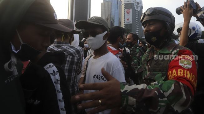 Personel TNI membubarkan massa yang melakukan aksi unjuk rasa di kawasan Patung Kuda Arjuna Wiwaha, Jakarta, Rabu (28/10/2020). [Suara.com/Angga Budhiyanto]