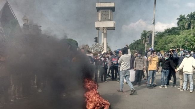 Massa penolak UU Cipta Kerja menggelar aksi bakar ban di kawasan Patung Kuda, Jakpus. (Suara.com/Arga)