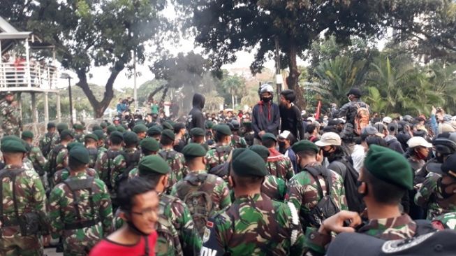 Pasukan TNI saat meminta massa aksi tolak UU Ciptaker mundur seusai insiden lemparan botol di kawasan Patung Kuda, Jakpus. (Suara.com/Bagaskara).