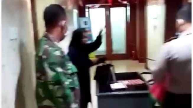 Tangkap layar video wanita  berhijab kedapatan membawa botol berisi bensin saat berkunjung ke Balai Kota. (istimewa)