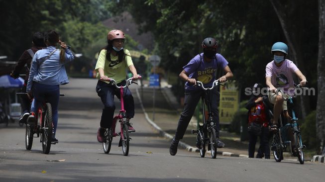 Pengunjung bersepeda di Taman Margasatwa Ragunan, Jakarta, Kamis (29/10/2020). [Suara.com/Angga Budhiyanto]