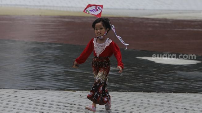 Seorang anak bermain layang-layang di Taman Mini Indonesia Indah (TMII), Jakarta, Jumat (30/10/2020). [Suara.com/Angga Budhiyanto]