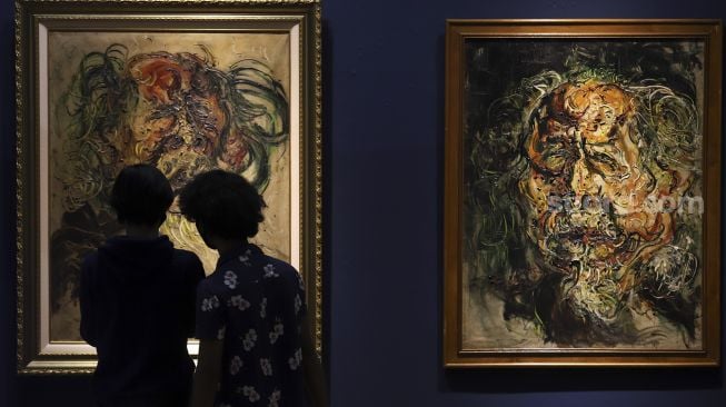 Pengunjung mengamati lukisan maestro seni lukis Affandi di pameran imersif Affandi: Alam, Ruang, Manusia di Galeri Nasional Indonesia, Jakarta, Jumat (30/10/2020). [Suara.com/Angga Budhiyanto]