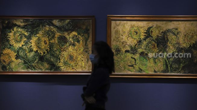 Penjaga berada di depan lukisan maestro seni lukis Affandi di pameran imersif Affandi: Alam, Ruang, Manusia di Galeri Nasional Indonesia, Jakarta, Jumat (30/10/2020). [Suara.com/Angga Budhiyanto]