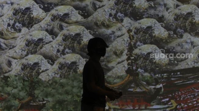 Pengunjung mengamati karya proyeksi video mapping di pameran imersif Affandi: Alam, Ruang, Manusia di Galeri Nasional Indonesia, Jakarta, Jumat (30/10/2020). [Suara.com/Angga Budhiyanto]