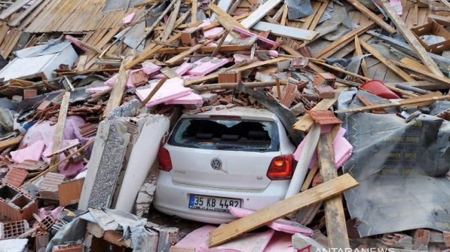 Dampak gempa bumi dahsyat di Turki, tampak satu unit mobil tertimpa reruntuhan material bangunan [ANTARA]
