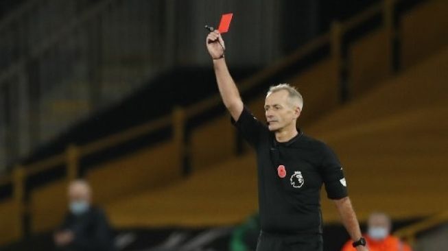 Wasit Martin Atkinson mengeluarkan kartu merah bagi pemain Crystal Palace Luka Milivojevic setelah melanggar pemain Wolverhampton dalam pertandingan Liga Premier Inggris yang berlangsung di Mollineux Stadium, Sabtu (31/10/2020). [AFP]