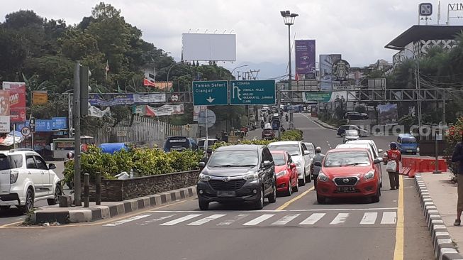 Lalu lintas Jalan Raya Puncak Bogor tepatnya di Gadog Ciawi terpantau ramai lancar, Sabtu (31/10/2020). [Suara.com/Andi Ahmad Sulaendi]