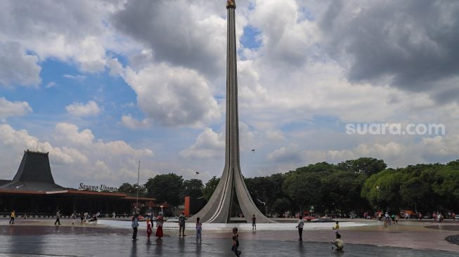 Anak - anak bermain di kawasan Tugu Api di Taman Mini Indonesia Indah, Jakarta Timur, Minggu (1/11). [Suara.com/Alfian Winanto]