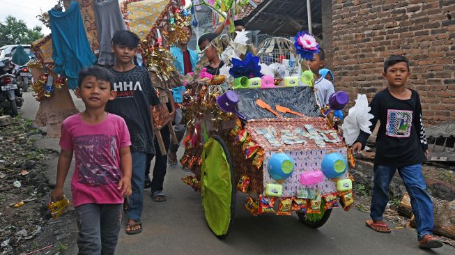 Warga menggotong aneka barang sedekah saat Perayaan Maulid Nabi Muhammad SAW di Kampung Tegalparang, Soyog, Serang, Banten, Minggu (1/11/2020). [ANTARA FOTO/Asep Fathulrahman]