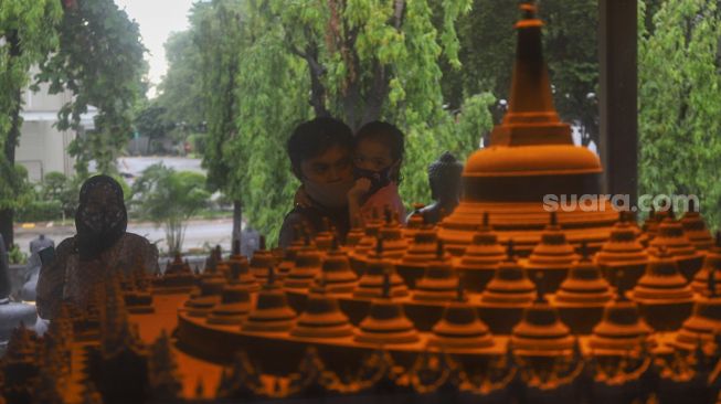 Anak - anak melihat replika Candi Borobudur di Taman Mini Indonesia Indah, Jakarta Timur, Minggu (1/11). [Suara.com/Alfian Winanto]