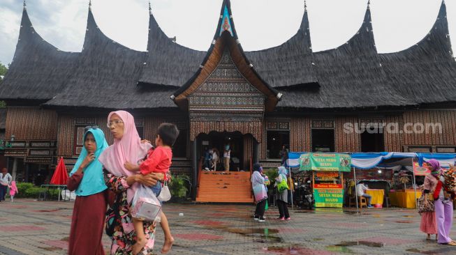 Warga berwisata di Anjungan Sumatra Barat di Taman Mini Indonesia Indah, Jakarta Timur, Minggu (1/11). [Suara.com/Alfian Winanto]