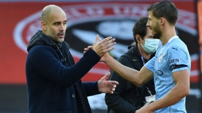 Pelatih Manchester City Josep Guardiola menyalami Ruben Dias usai pertandingan pekan ketujuh Liga Premier Inggris kontra Sheffield United yang berlangsung di Bramall Lane, Sabtu (31/10/2020). [AFP]