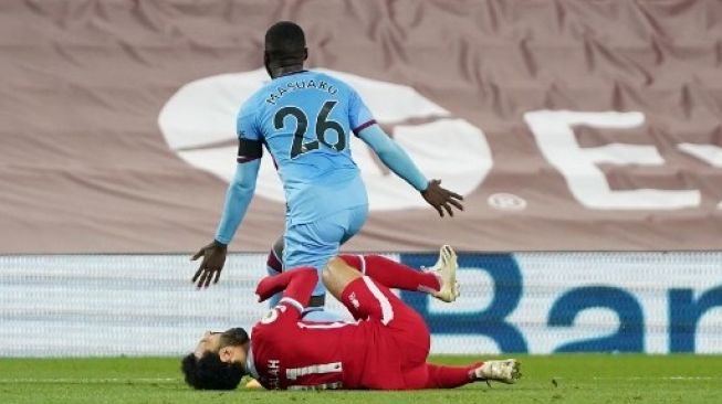 Pemain Liverpool Mohamed Salah dijatuhkan di kotak penalti oleh pemain West Ham dalam pertandingan Liga Premier Inggris yang digelar di Anfield, Minggu (1/11/2020). [AFP]