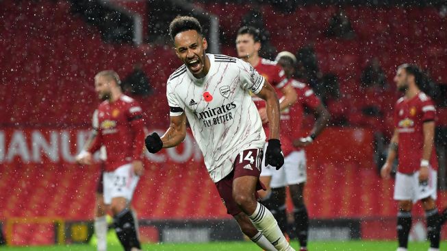 Striker Arsenal Pierre-Emerick Aubameyang usai mencetak gol pembuka dari titik penalti selama pertandingan sepak bola Liga Inggris antara Manchester United melawan Arsenal di Old Trafford, Manchester, Inggris, Minggu (1/11). [PHIL NOBLE / POOL / AFP]