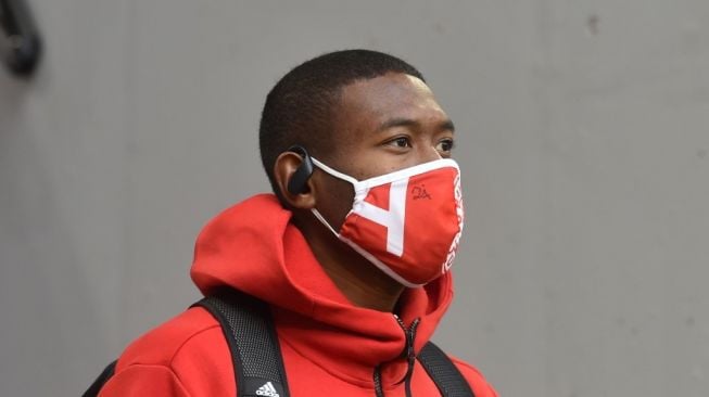 David Alaba mengenakan masker pelindung saat ia tiba di markas Hertha Berlin dalam laga lanjutan Bundesilga Jerman, Minggu (4/10/2020). [Christof Stache / AFP]