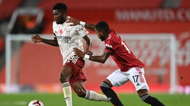 Gelandang Manchester United Fred (kanan) berebut bola dengan pemain Arsenal, Thomas Partey dalam laga lanjutan Liga Inggris, di Old Trafford, Manchester, Senin (2/1/2020) dini hari WIB. [Shaun Botterill / POOL / AFP]