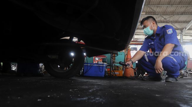 Petugas melakukan uji emisi kendaraan bermotor di Kantor Dinas Lingkungan Hidup DKI Jakarta, Kramat Jati, Jakarta, Selasa (3/11/2020). [Suara.com/Angga Budhiyanto]