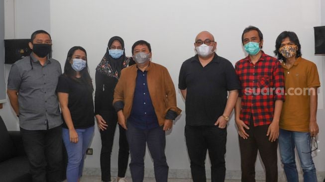 CEO PT Arkadia Digital Media Tbk, William Martaputra (ketiga kanan) dan CEO PT Media Musik Proaktif Agi Sugiyanto (keempat kiri) beserta para jajaran berfoto bersama usai penandatanganan kerja sama program pencarian penyanyi berbakat di Kantor Suara.com, Jakarta Selatan, Selasa (3/11). [Suara.com/Alfian Winanto]