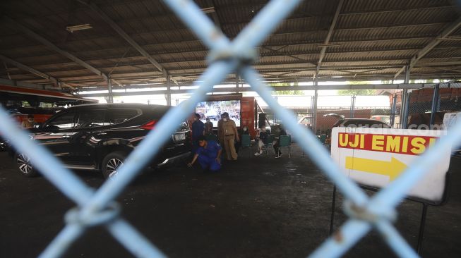 Petugas melakukan uji emisi kendaraan bermotor di Kantor Dinas Lingkungan Hidup DKI Jakarta, Kramat Jati, Jakarta, Selasa (3/11/2020). [Suara.com/Angga Budhiyanto]