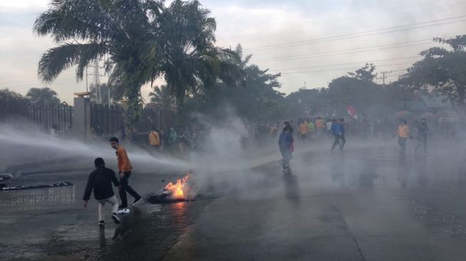 Massa aksi penolak Omnibus Law ditembak water canon cari arah dalam Gedung DPRD Kaltim. [Suara.com/Alisha Aditya]