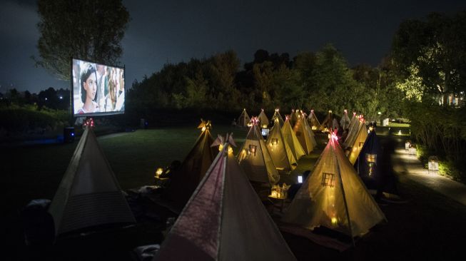 Pengunjung berada di dalam tenda saat menyaksikan film di bioskop outdoor Tenda di Bawah Bintang, Parongpong, Kabupaten Bandung Barat, Jawa Barat, Rabu (4/11/2020). [ANTARA FOTO/M Agung Rajasa]