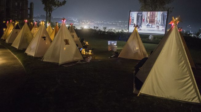 Pengunjung berada di dalam tenda saat menyaksikan film di bioskop outdoor Tenda di Bawah Bintang, Parongpong, Kabupaten Bandung Barat, Jawa Barat, Rabu (4/11/2020). [ANTARA FOTO/M Agung Rajasa]