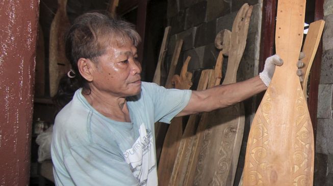 Seniman Dayak dan pembuat Sape Kalbar Christian Mara memperlihatkan sejumlah sape buatannya di kediamannya di Kampung Wonodadi, Desa Arang Limbung, Kecamatan Sungai Raya, Kabupaten Kubu Raya, Kalimantan Barat, Kamis (5/11/2020). [ANTARA FOTO/Jessica Helena Wuysang]