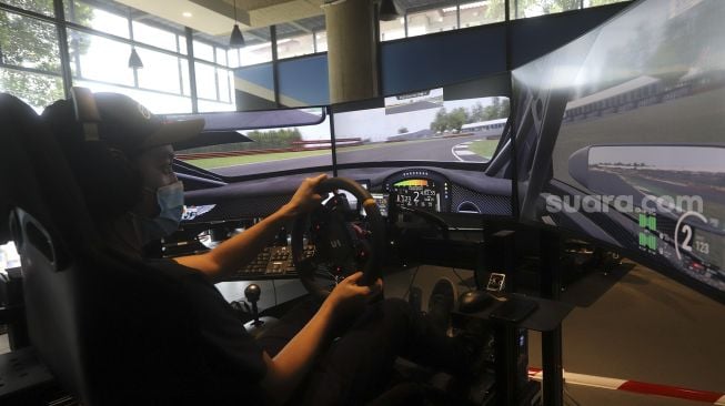 Pembalap melakukan sesi latihan menggunakan simulator balap di P1 Academy Motorsport Indonesia (ADMI), Kebayoran Baru, Jakarta, Jumat (6/11/2020). [Suara.com/Angga Budhiyanto]