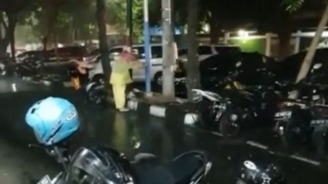 Ristianisa mendadak viral karena memayungi seekor kucing yang lagi makan saat hujan di pinggir jalan. (@kulinerdisolo)