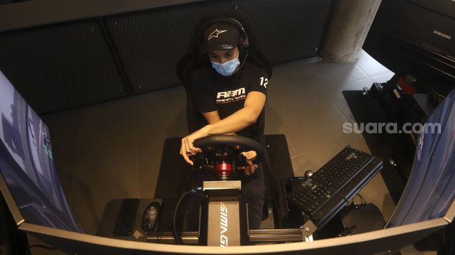 Pembalap melakukan sesi latihan menggunakan simulator balap di P1 Academy Motorsport Indonesia (ADMI), Kebayoran Baru, Jakarta, Jumat (6/11/2020). [Suara.com/Angga Budhiyanto]