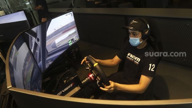 Pembalap melakukan sesi latihan menggunakan simulator balap di P1 Academy Motorsport Indonesia (ADMI), Kebayoran Baru, Jakarta, Jumat (6/11/2020). [Suara.com/Angga Budhiyanto]