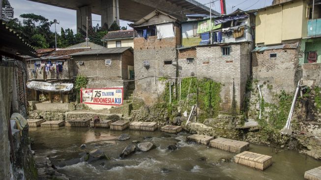 Warga membersihkan sampah yang menyangkut di keramba budidaya ikan di aliran Sungai Cikapundung, Bandung, Jawa Barat, Jumat (6/11/2020). [ANTARA FOTO/Novrian Arbi]