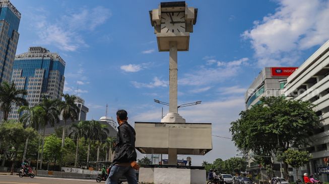 Pejalan kaki melintas disekitar area Tugu Jam Thamrin di Jl. MH. Thamrin, Jakarta Pusat, Minggu (8/11). [Suara.com/Alfian Winanto]