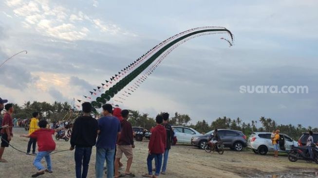 Sekelompok pemuda bermain layangan naga di Jalur Jalan Lintas Selatan (JJLS), Minggu (8/11/2020). - (SuaraJogja.id/Hiskia Andika)